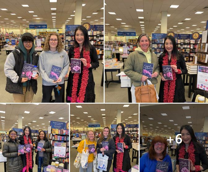 Smiling readers holding Orchid Blooming, Goodbye Orchid and Always Orchid standing next to author Carol Van Den Hende wearing a black dress and pink scarf inside a large well-lit store filled with shelves of books